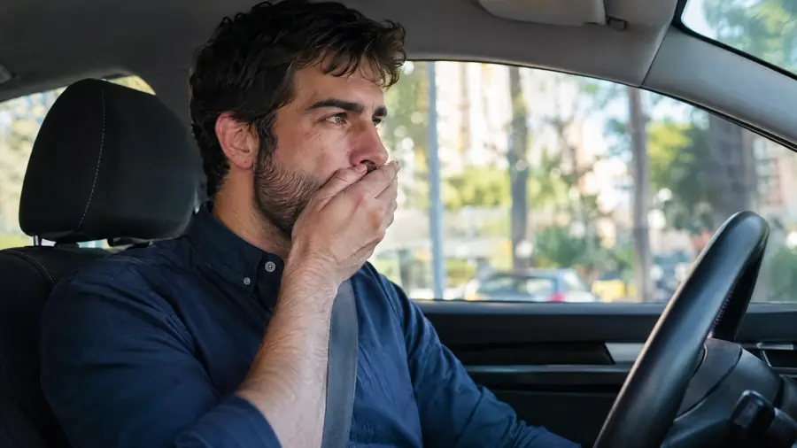 Hombre comprobando su aliento antes de ir al trabajo