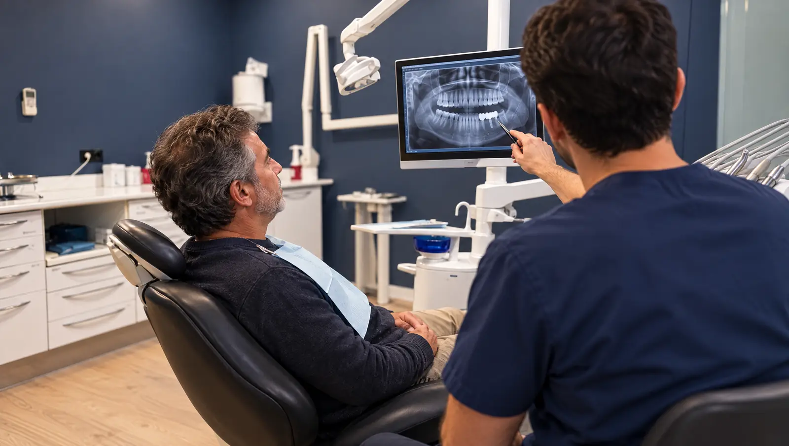 Paciente viendo su radiografía mientras el odontólogo explica el puente dental en Odontis Rivas