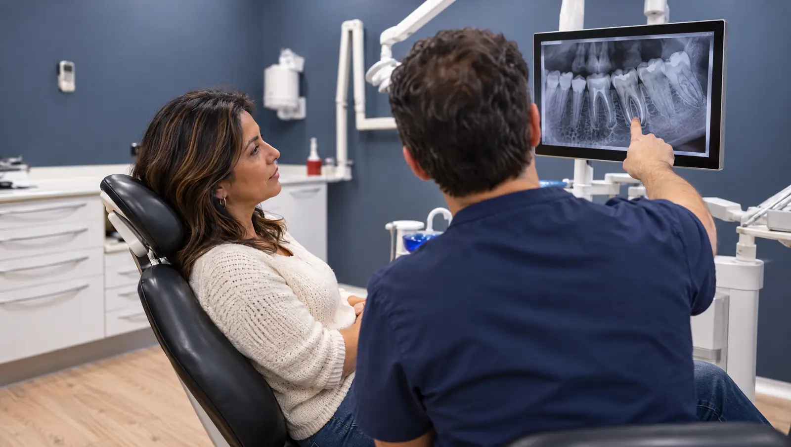 Paciente viendo la radiografía de la raíz antes de una apicectomía en Odontis Rivas