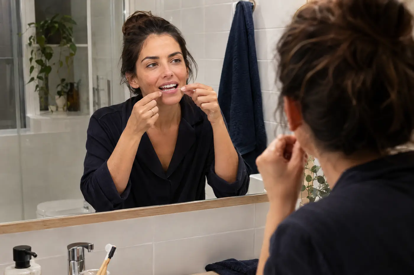 Mujer usando seda dental con cuidado