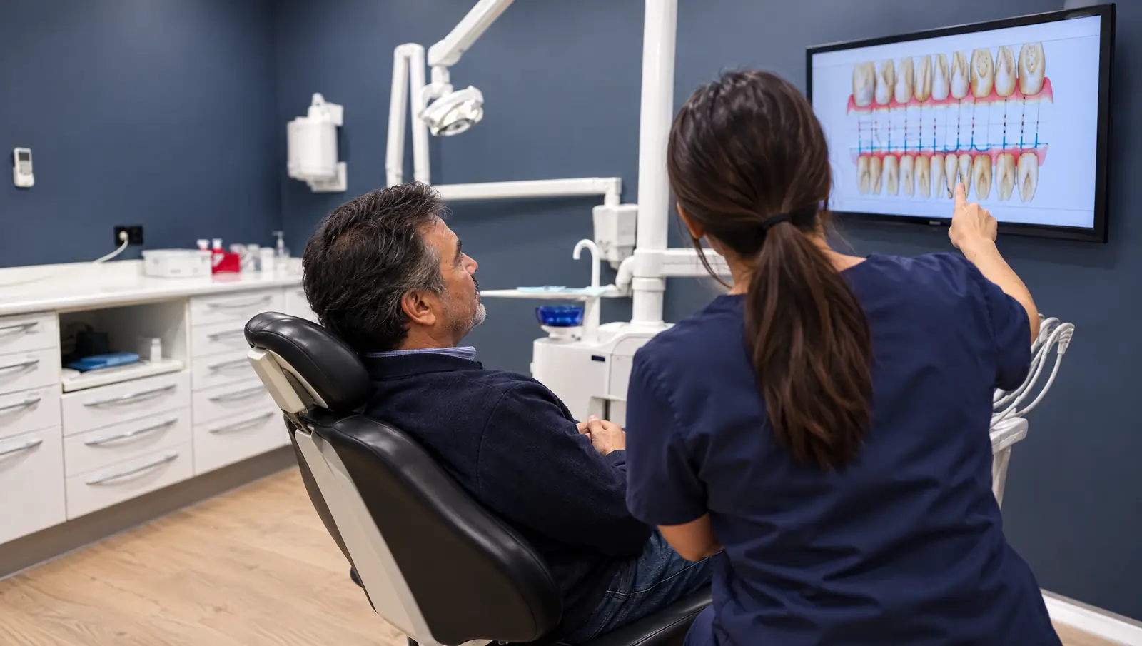Paciente viendo su periodontograma en el monitor con la higienista en Odontis Rivas